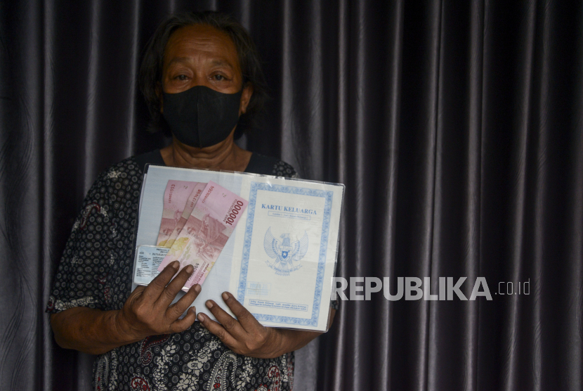 Warga menunjukan uang senilai Rp 300.000 saat pembagian Bantuan Langsung Tunai (BLT) subsidi Bahan Bakar Minyak (BBM) di kawasan Gambir, Jakarta, Jumat (2/9/2022). 104 Ribu Keluarga di Lombok Timur Terima BLT BBM