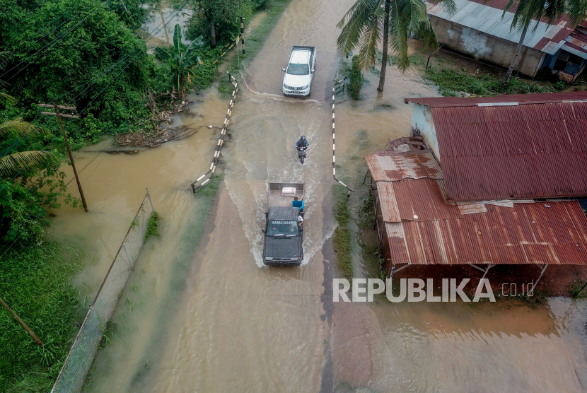 Foto udara kendaraan melewati Jalan Lirik yang terendam banjir di Kota Baru, Jambi, Selasa (23/5/2023). Jambi tengah akan mengalami musim pancaroba dalam waktu dekat.  