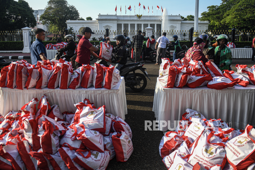 Pasukan Pengamanan Presiden (Paspampres) membagikan sembako dari Presiden Joko Widodo kepada warga di halaman Istana Merdeka, Jakarta, Senin (8/4/2024). 