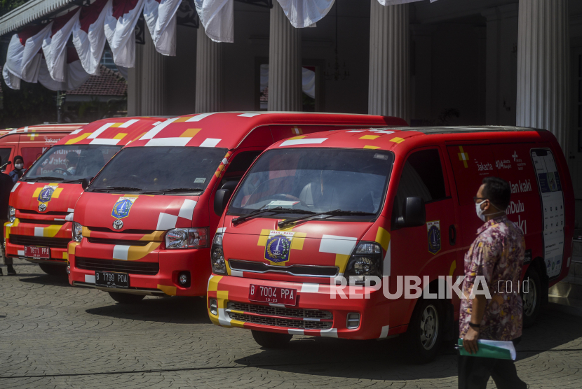 Pekerja berjalan di dekat mobil vaksin keliling di Balai Kota Jakarta, Kamis (8/7). (Ilustrasi)