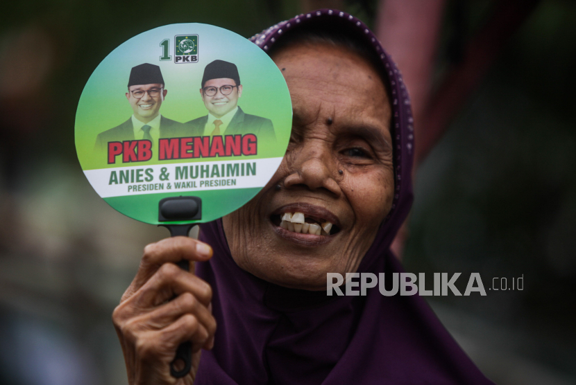 Seorang warga memperlihatkan kipas bergambarkan dukungan untuk pasangan Anies Baswedan-Muhaimin Iskandar saat kampanye di pemukiman nelayan Muara Angke, Jakarta, Selasa (2/1/2024).