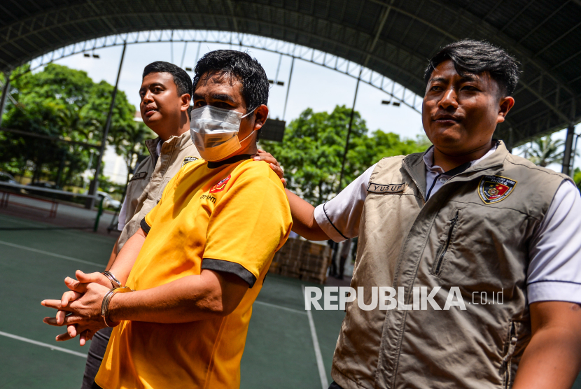 Petugas Direktorat Reserse Kriminal Khusus (Ditreskrimsus) Polda Jawa Barat menggiring seorang tersangka kasus pengurangan takaran minyak goreng merek MinyaKita saat konferensi pers di Polda Jabar, Bandung, Jawa Barat, Senin (10/3/2025). Polda Jabar berhasil mengamankan sebanyak 2.520 botol kosong tanpa merek, 449 dus berisi 12 botol minyak goreng merek MinyaKita dan dua unit dispenser meja serta beberapa barang bukti lainnya dari seorang tersangka asal Kabupaten Subang atas kasus pengurangan takaran MinyaKita dari 1 liter menjadi 750 mililiter yang tidak sesuai dengan ketetapan SNI dan tidak memiliki izin edar. 