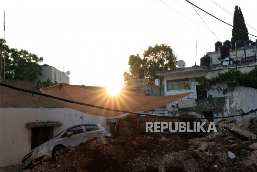 Mobil rusak dan puing-puing di jalan setelah serangan tentara Israel di kota Jenin, Tepi Barat, (5/7/2023).