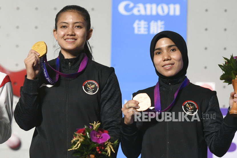 Atlet panjat tebing Indonesia Desak Made Rita Kusuma Dewi (kiri) dan Rajiah Sallsabillah menunjukkan medali nomor speed putri Asian Games 2022 di Shaoxing Keqiao Yangshan Sport Climbing Centre, Shaoxing, China, Selasa (3/10/2023). Desak berhasil meraih emas usai menang dengan catatan waktu 6,364 detik dan Rajiah Sallsabillah meraih perunggu dengan mencatatkan waktu 6.879 detik . ANTARA FOTO/Hafidz Mubarak A/rwa.