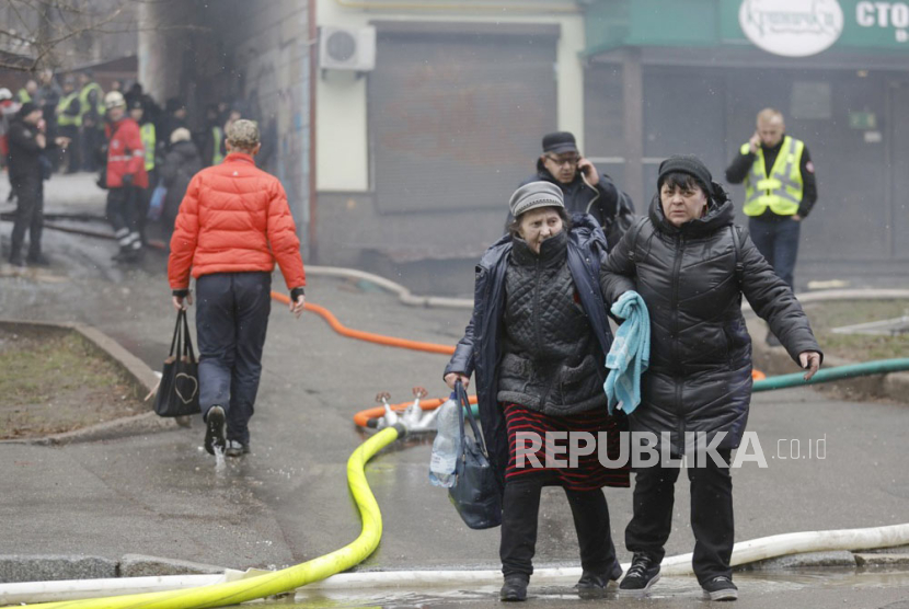 Wanita setempat meninggalkan lokasi bangunan yang rusak setelah serangan rudal di Kyiv (Kiev), Ukraina, 2 Januari 2024. 