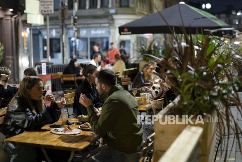 Sejumlah orang menikmati makan dan minum di sebuah restoran di Northern Quarter Manchester, Inggris, Selasa (22/9). 