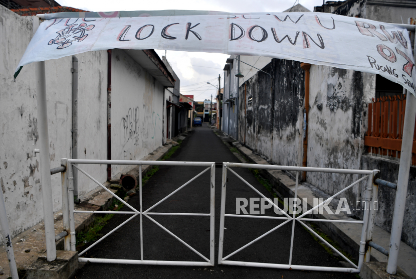 Suasana depan pintu masuk Kampung Pucang Sewu yang melakukan karantina wilayah, Surabaya, Jawa Timur, Ahad (5/4/2020). Karantina wilayah tersebut dilakukan oleh warga di kampung itu guna mencegah penyebaran Virus Corona (COVID-19)