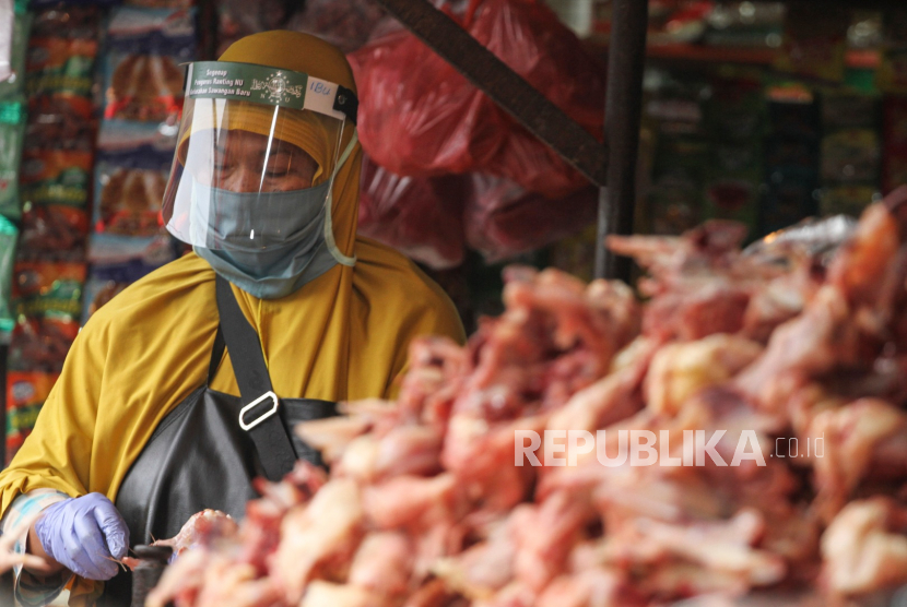 Seorang pedagang daging ayam menggunakan pelindung wajah saat berjualan di Pasar Kemiri Muka, Depok, Jawa Barat, Kamis (30/4/2020). Penggunaan alat pelindung wajah tersebut sebagai salah satu upaya pencegahan penyebaran virus corona atau COVID-19