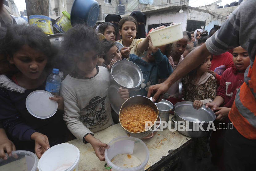 Warga Palestina antre untuk mendapatkan makanan selama pengeboman Israel yang sedang berlangsung di Jalur Gaza di Rafah pada Senin, 13 November 2023.