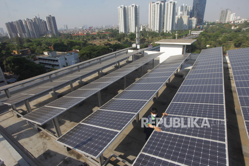 Pekerja tengah mengecek panel surya di atas gedung,  di Jakarta. Salah satu lambatnya pengembangan EBT di Indonesia adalah investasi yang mahal. Investasi yang mahal ini mengerek harga jual listrik dari investor ke PLN.