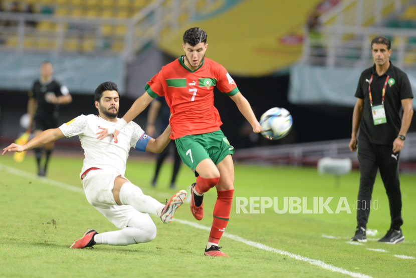 Pesepak bola Timnas Maroko Anas Alaoui berebut bola dengan pesepak bola Timnas Iran Erfan Darvish Aali dalam pertandingan babak 16 besar Piala Dunia U-17 2023 di Stadion Gelora Bung Tomo,Surabaya, Selasa (21/11/2023). 