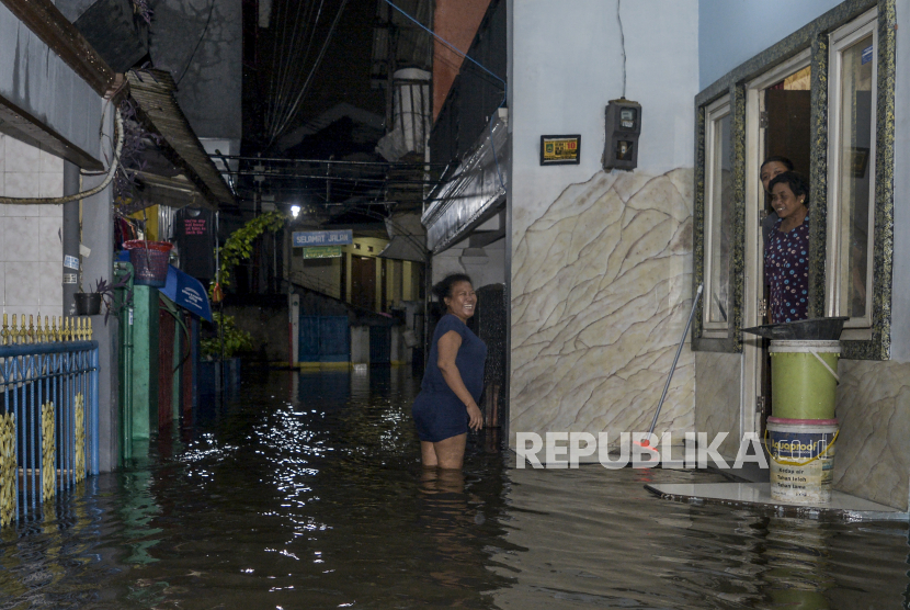 Warga menyusuri jalan yang terendam banjir di Jalan Inpres 2, Larangan Utara, Ciledug, Tangerang, Banten. Hujan deras menyebabkan pohon tumbang di Pasar Kemis, Kabupaten Tangerang.