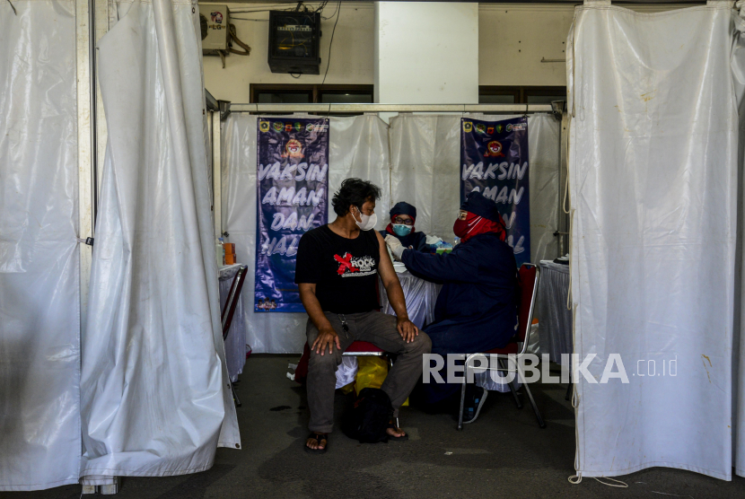 Tenaga kesehatan menyuntikan vaksin Covid-19 kepada warga saat vaksinasi massal di Stadion Pakansari, Cibinong, Kabupaten Bogor, Jawa Barat, Sabtu (26/6). Vaksinasi massal yang diselenggarakan oleh Polri secara serentak di 34 Polda itu dilakukan kepada 1.031.056 masyarakat di Indonesia dalam rangka memperingati HUT Bhayangkara ke-75. Republika/Putra M. Akbar