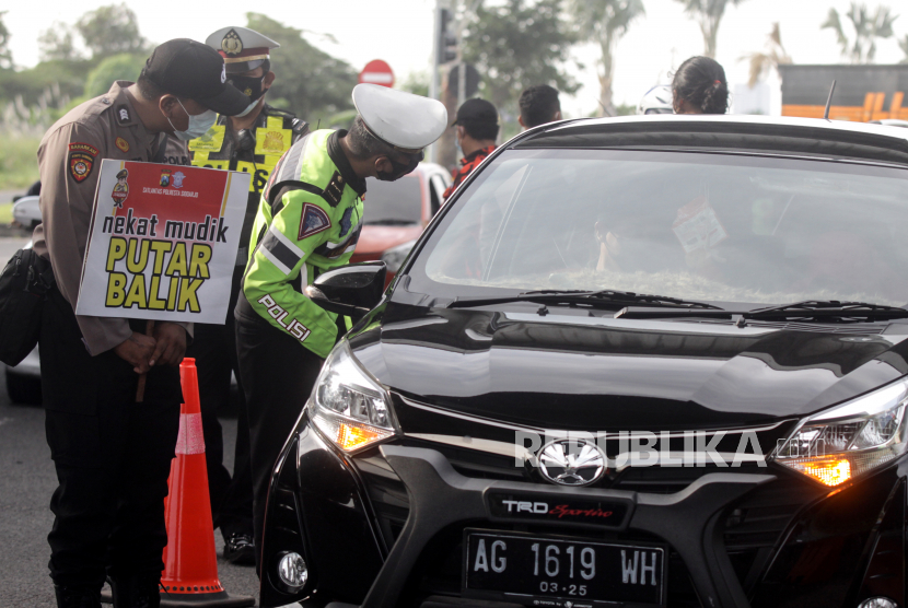 Petugas memeriksa kelengkapan surat dan KTP saat hari pertama penyekatan larangan mudik di perbatasan Kota Surabaya-Kabupaten Sidoarjo di Tambak Sumur, Sidoarjo, Jawa Timur, Kamis (6/5/2021).