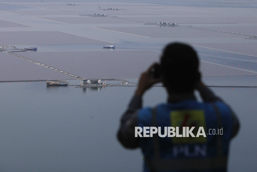 Sebuah kapal melintas di dekat solar panel pada proyek PLTS Terapung di Waduk Cirata, Kabupaten Purwakarta, Jawa Barat, Selasa (26/9/2023).