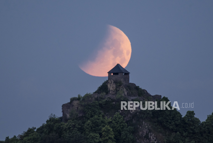  Bulan saat gerhana di atas Kastil Salgo dilihat dari Salgotarjan, Hungaria, Senin pagi, 16 Mei 2022. Pandangan Islam Terhadap Fenomena Gerhana Matahari dan Bulan