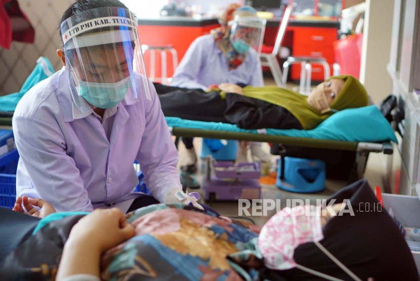Petugas melakukan pengambilan darah pendonor di ruang layanan donor darah PMI Tulungagung, Tulungagung, Jawa Timur, Selasa (21/4/2020). Golongan darah pendonor plasma konvalesen harus sama dengan pasien Covid-19. 