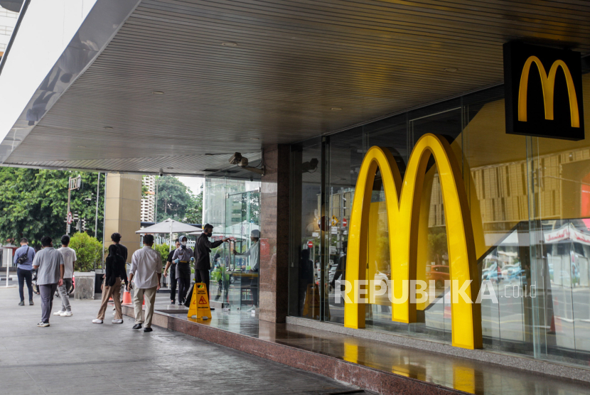 Warga berjalan dekat gerai McDonalds yang kembali beroperasi di Jalan MH Thamrin, Jakarta, Ahad (5/11/2023). Gerai makanan cepat saji McDonalds dan Starbucks kembali beroperasi pasca Aksi Damai Aliansi Rakyat Indonesia Bela Palestina yang digelar di Monas.
