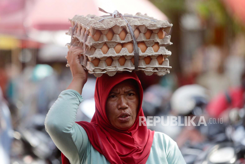 Penjual membawa telur dengan cara menjunjung di atas kepalanya (ilustrasi)