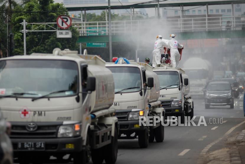 Petugas Palang Merah Indonesia (PMI) Jakarta Pusat menyemprotkan cairan disinfektan menggunakan mobil blawer di kawasan pusat perbelanjaan Tanah Abang, Jakarta, Sabtu (28/3). Penyemprotan  tersebut sebagai upaya mengantisipasi penyebaran virus corona COVID-19 di kawasan pusat perbelanjaan