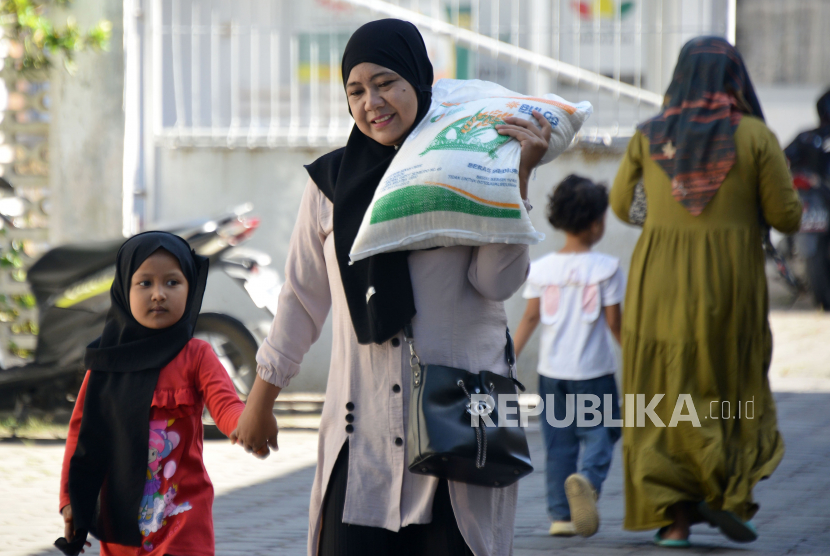 Warga membawa beras usai penyaluran di kantor PT Pos  Indonersia (Persero) Cabang Banda Aceh, Aceh, Jumat (12/5/2023). PT POS Indonesia (Persero ) menargetkan distribusi bantuan pangan beras tahap kedua kepada 21,3 juta keluarga penerima manfaat (KPM) di 38 provinsi selesai pada minggu kedua Mei 2023. ANTARA FOTO/Ampelsa/foc.