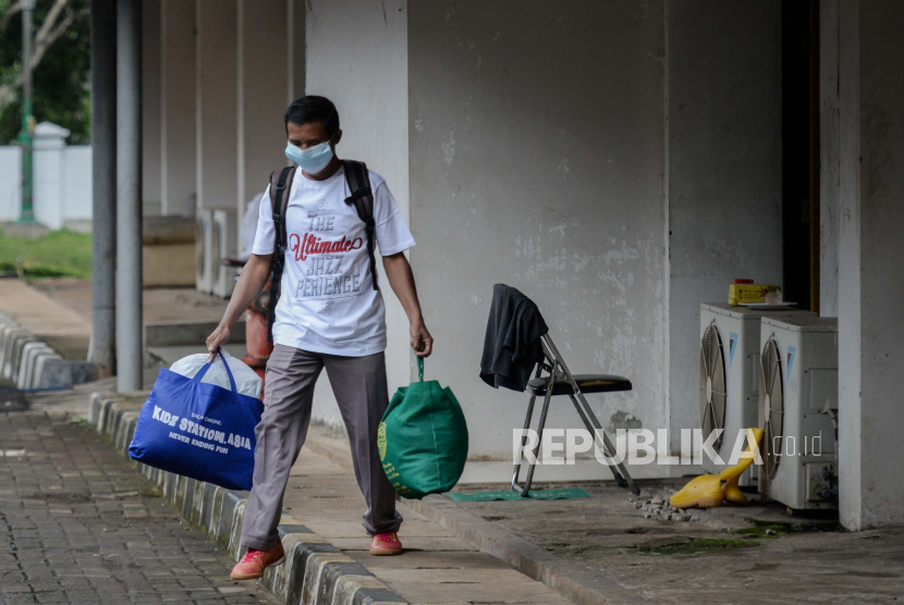 Pasien covid-19 sembuh berjalan meninggalkan ruangan isolasi Graha Wisata Ragunan di Jakarta.