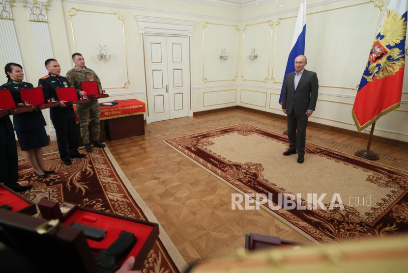 Prajurit Rusia mendapatkan penghargaan oleh Presiden Rusia Vladimir Putin dalam pertemuan di luar Moskow, Rusia, Senin, 1 Januari 2024. Putin tampak berjarak dengan tamu undangan.
