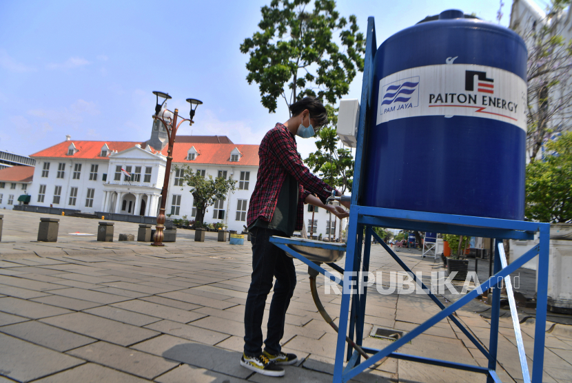 Pengunjung mencuci tangan saat memasuki kawasan wisata Kota Tua di Jakarta, Sabtu (24/10/2020). Kawasan Kota Tua dibuka kembali pascapenerapan PSBB transisi dengan tetap menerapkan protokol kesehatan untuk mencegah penyebaran COVID-19.