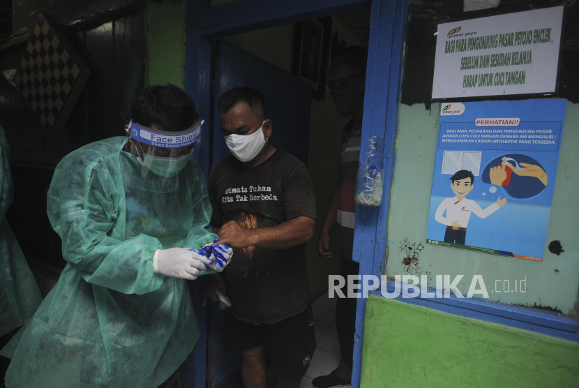 Petugas memberikan cap kepada pedagang usai menjalani tes swab di Pasar Petojo Udik, Gambir, Jakarta (Ilustrasi). Kenaikan kasus Covid-19 di Jakarta karena pelacakan orang-orang tanpa gejala (OTG) yang terinfeksi virus ini di Ibu Kota.
