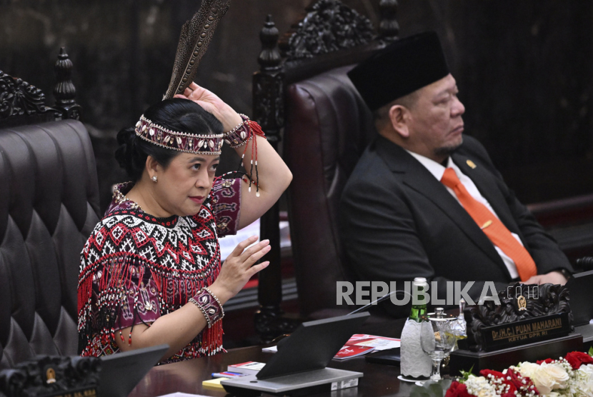 House Speaker Puan Maharani, left, wearing traditional outfit from West Kalimantan, adjusts her headwear as the Speaker of the Regional Representative Council La Nyalla Mattalitti, right, looks on during President