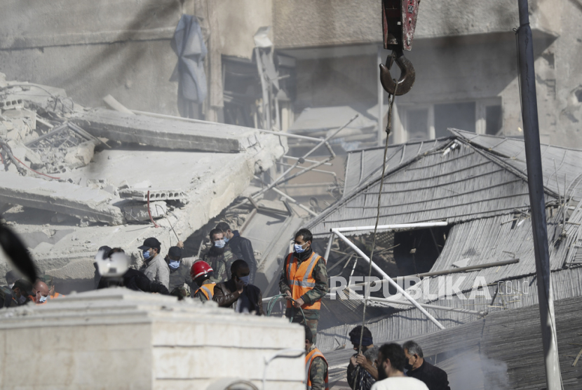 Layanan darurat bekerja di sebuah gedung yang terkena serangan udara di Damaskus, Suriah, Sabtu, (20/1/2024).