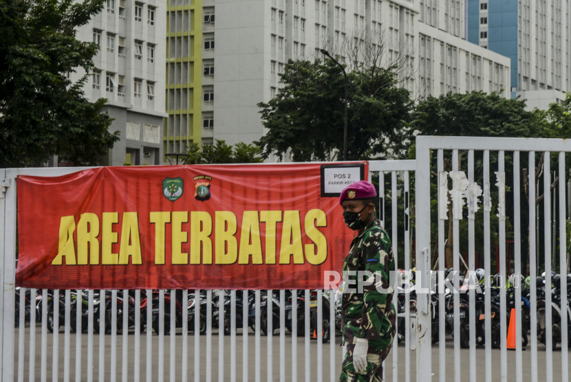 Anggota TNI berjaga di Wisma Atlet Kemayoran yang difungsikan sebagai rumah sakit darurat di Jakarta, Selasa (14/4). Pemerintah akan mempersiapkan tiga tower tambahan di Wisma Atlet Kemayoran yaitu, tower 2, 4 dan 5, untuk menambah daya tampung Rumah Sakit Darurat COVID-19