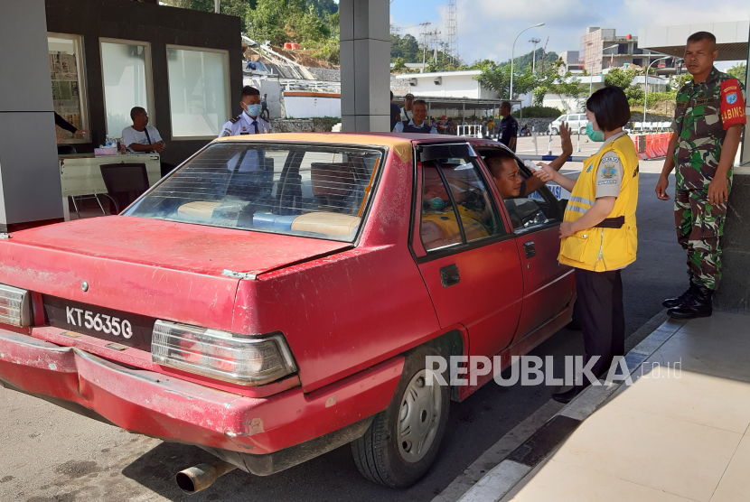 Warga memasuki area Pos Lintas Batas Negara (PLBN) Entikong di Kabupaten Sanggau, Kalimantan Barat, yang berbatasan dengan Malaysia. 