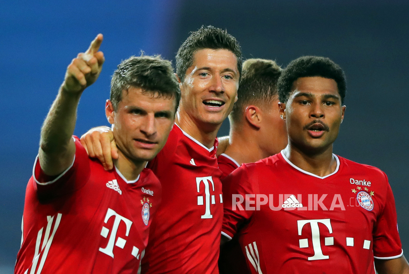  Serge Gnabry (kanan) merayakan dengan rekan setimnya Thomas Mueller (kiri) dan Robert Lewandowski (tengah) setelah mencetak keunggulan 2-0 pada pertandingan semifinal Liga Champions  antara Olympique Lyon dan Bayern Munich di Lisbon, Portugal, pada Rabu (19/8)..