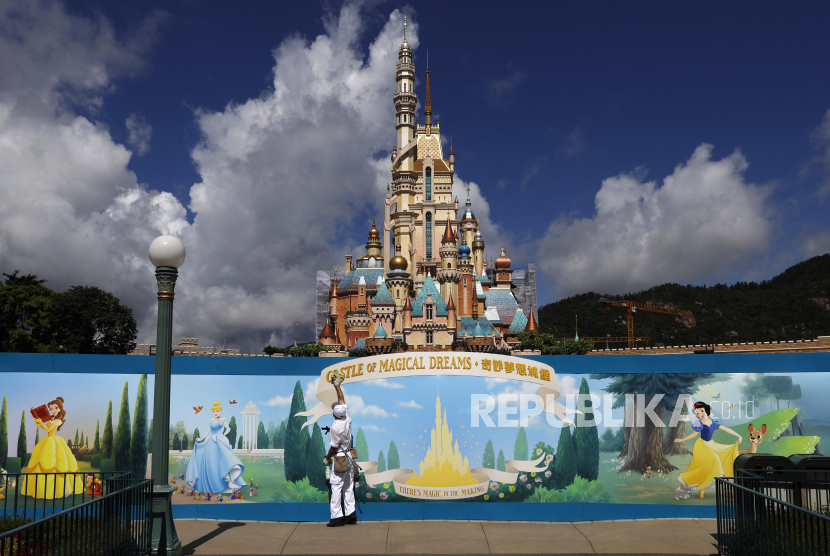 Seorang anggota staf membersihkan poster untuk mencegah penyebaran coronavirus baru, di Disneyland Hong Kong pada hari Rabu, 17 Juni 2020, sehari sebelum taman hiburan dibuka kembali setelah hampir empat bulan penutupan karena pandemi coronavirus. Pada 17 Juli 1955, Disneyland dibuka untuk pertama kalinya di dunia.