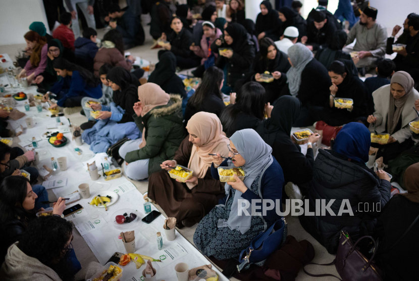 Umat muslim sedang makan saat mengikuti buka puasa bersama di Masjid Rawdah di Bradford, Inggris, Ahad (9/4/2023).