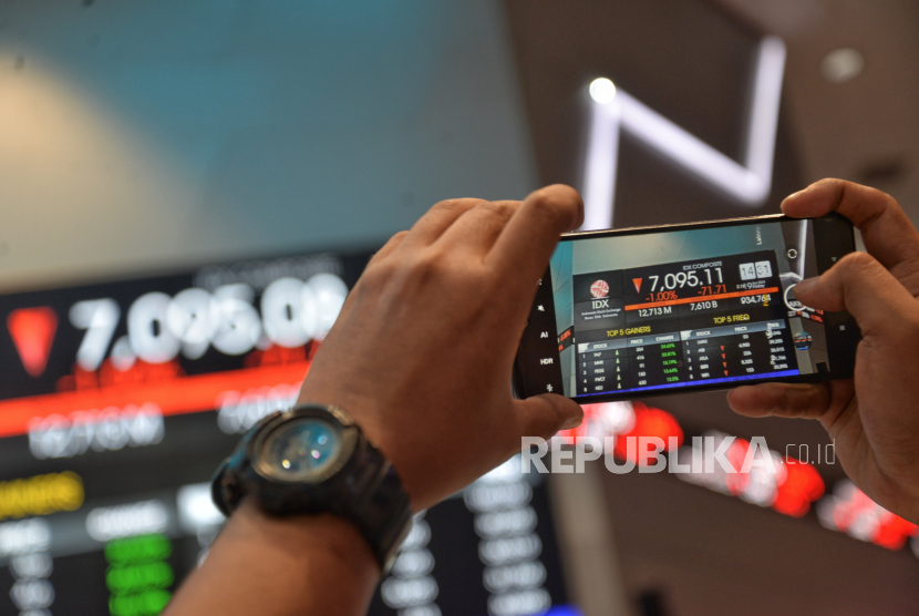 Karyawan memfoto layar elektronik yang menampilkan pergerakan Indeks Harga Saham Gabungan (IHSG) di Bursa Efek Indonesia (BEI).