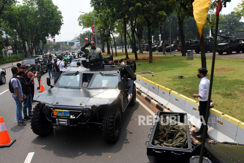 Warga berpose saat menaiki kendaraan tempur milik TNI di depan Istana Merdeka Jakarta, Senin (4/10/2021). Pameran alutsista tersebut dalam rangka menyemarakkan HUT ke-76 TNI yang diperingati setiap tanggal 5 Oktober. 