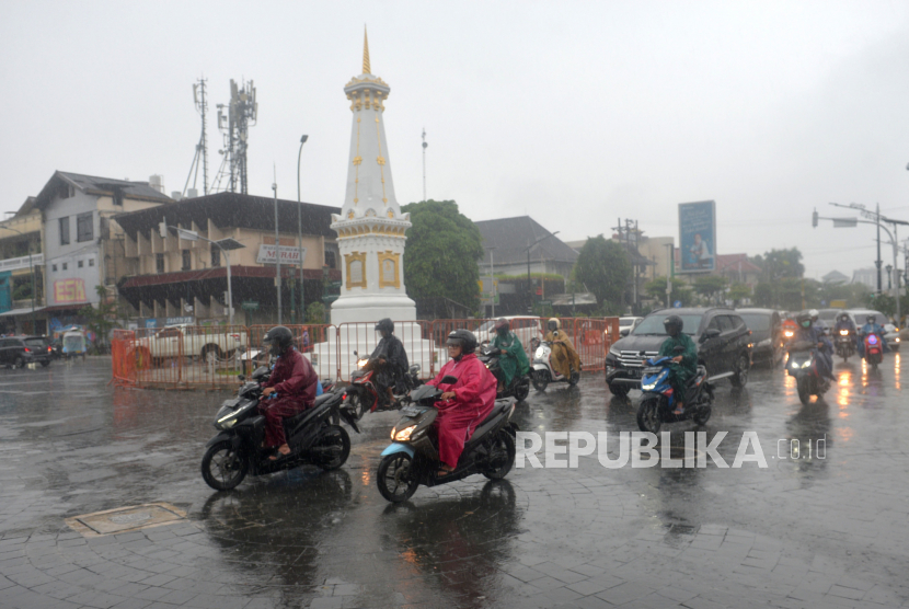 Pengendara menggunakan jas hujan menembus hujan di kawasan Tugu Pal Putih, Yogyakarta. Sidang UNESCO akan membahas sumbu filosofi Yogyakarta pada September mendatang.