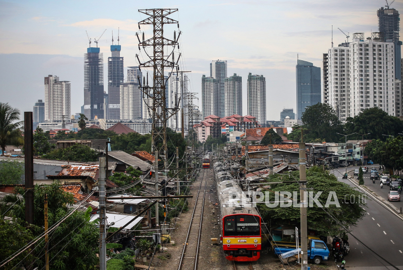 KRL Commuter Line melintas dengan latar belakang gedung bertingkat di Pejompongan, Jakarta, Rabu (6/1/2021). ilustrasi