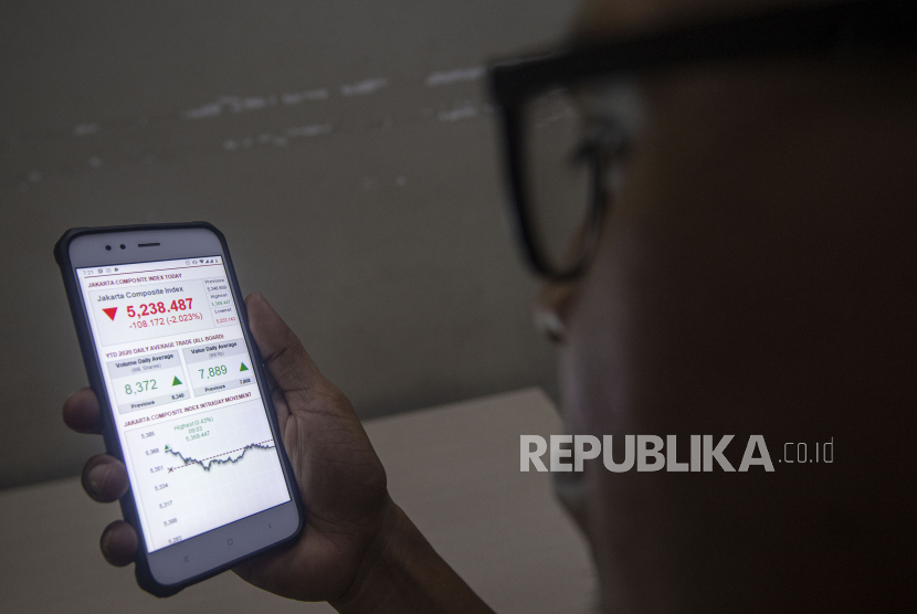 Warga mengamati pergerakan harga saham pada layar telepon pintarnya,  di Jakarta, Senin (31/8). Indeks Harga Saham Gabungan (IHSG) Selasa (1/9) ditutup menguat 72 poin atau naik 1,38 persen ke level 5.310. 