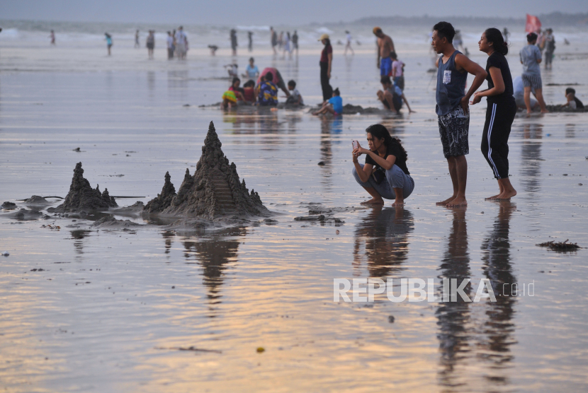 Sejumlah wisatawan menikmati suasana Pantai Double Six di Seminyak, Badung, Bali, Minggu (3/1/2021). 