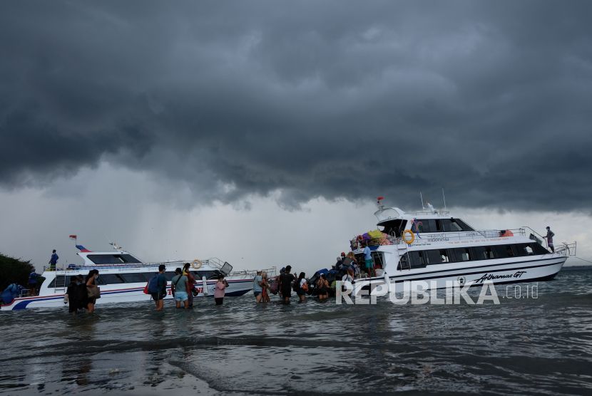 Penumpang mengantre saat akan naik kapal cepat. Kapal cepat Tanjung Pandan-Pangkal Balam menunda keberangkatan karena cuaca buruk.