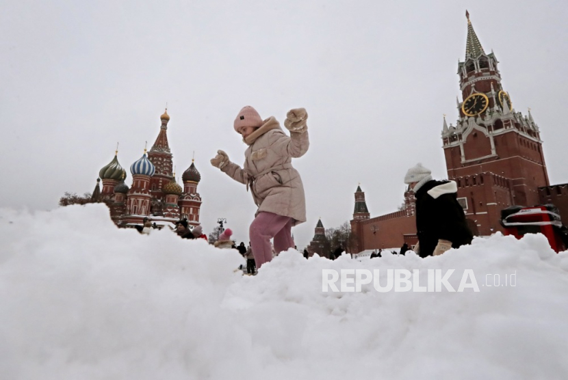Orang-orang berjalan di Lapangan Merah yang tertutup salju di luar Kremlin di Moskow, Rusia, (27/11/2023).