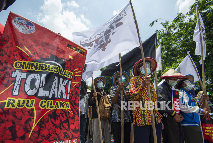 Sejumlah demonstran membawa poster dalam aksi jalan kaki menuju Istana Merdeka di Jalan Salemba, Jakarta, Selasa (20/10/2020). Aksi gabungan buruh, petani, mahasiswa, dan pelajar yang dilakukan bersamaan dengan setahun pemerintahan Presiden Joko Widodo dan Wakil Presiden Ma