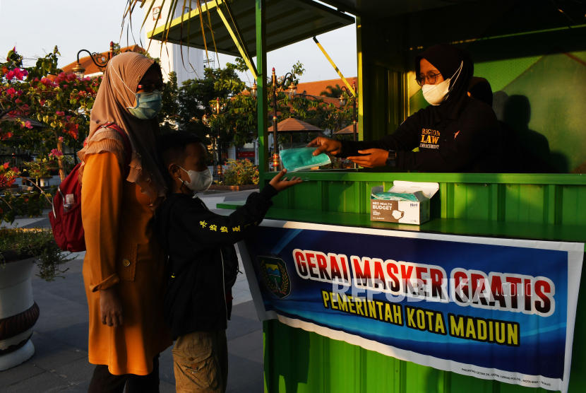 Petugas memberikan masker medis kepada warga di gerai masker gratis Kota Madiun, Jawa Timur, Kamis (2/9/2021). Pemkot Madiun menyediakan masker medis secara gratis melalui gerai masker untuk warga yang membutuhkan guna mencegah penyebaran COVID-19. 