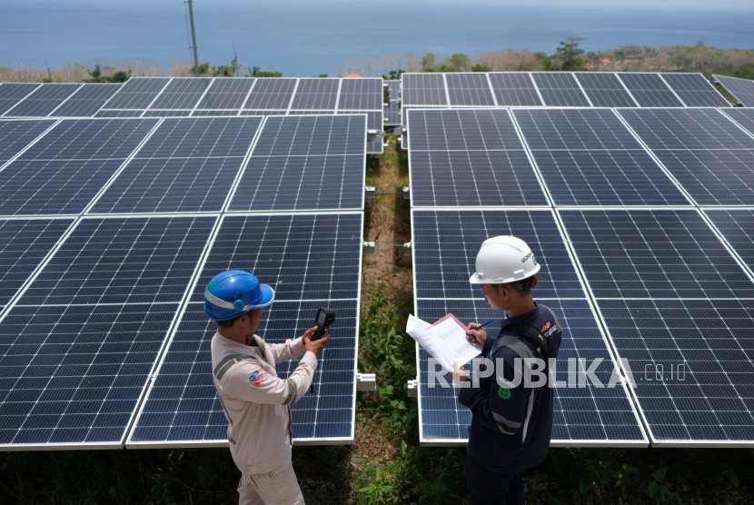 Dua petugas PLN Indonesia Power UBP Bali memeriksa titik panel surya pada Pembangkit Listrik Tenaga Surya (PLTS) di Pulau Nusa Penida, Klungkung, Bali, Selasa (22/10/2024). 