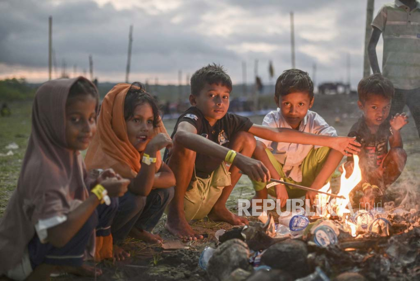 Anak-anak etnis Rohingya duduk di sekitar api unggun di kamp mereka dekat pantai di Pidie, provinsi Aceh, Indonesia, Jumat, 15 Desember 2023. Sejak November, lebih dari 1.500 pengungsi Rohingya yang melarikan diri dari Bangladesh dengan perahu telah mendarat di provinsi Aceh di utara Indonesia, tiga perempatnya adalah perempuan dan anak-anak. Dengan banyaknya warga Rohingya yang mencoba menyeberang dalam beberapa minggu terakhir, tidak ada yang tahu berapa banyak perahu yang tidak berhasil menyeberang, dan berapa banyak orang yang meninggal.