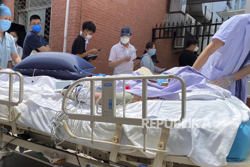 Seorang pasien didorong melewati warga yang mengantre untuk menunggu tes di klinik, Beijing, Cina, Senin (15/6). Ibukota Cina bersiap-siap untuk gelombang kedua virus Corona setelah lebih dari 100 kasus baru dilaporkan baru-baru ini di kota yang belum pernah melihat kasus penularan lokal dalam lebih dari sebulan