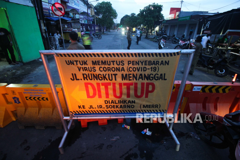 Warga beraktivitas di Jalan Rungkut Menanggal, Surabaya, Jawa Timur, Ahad (5/4/2020). Warga setempat menutup jalan penghubung Kota Surabaya-Sidoarjo itu untuk memutus penyebaran Virus Corona (COVID-19).